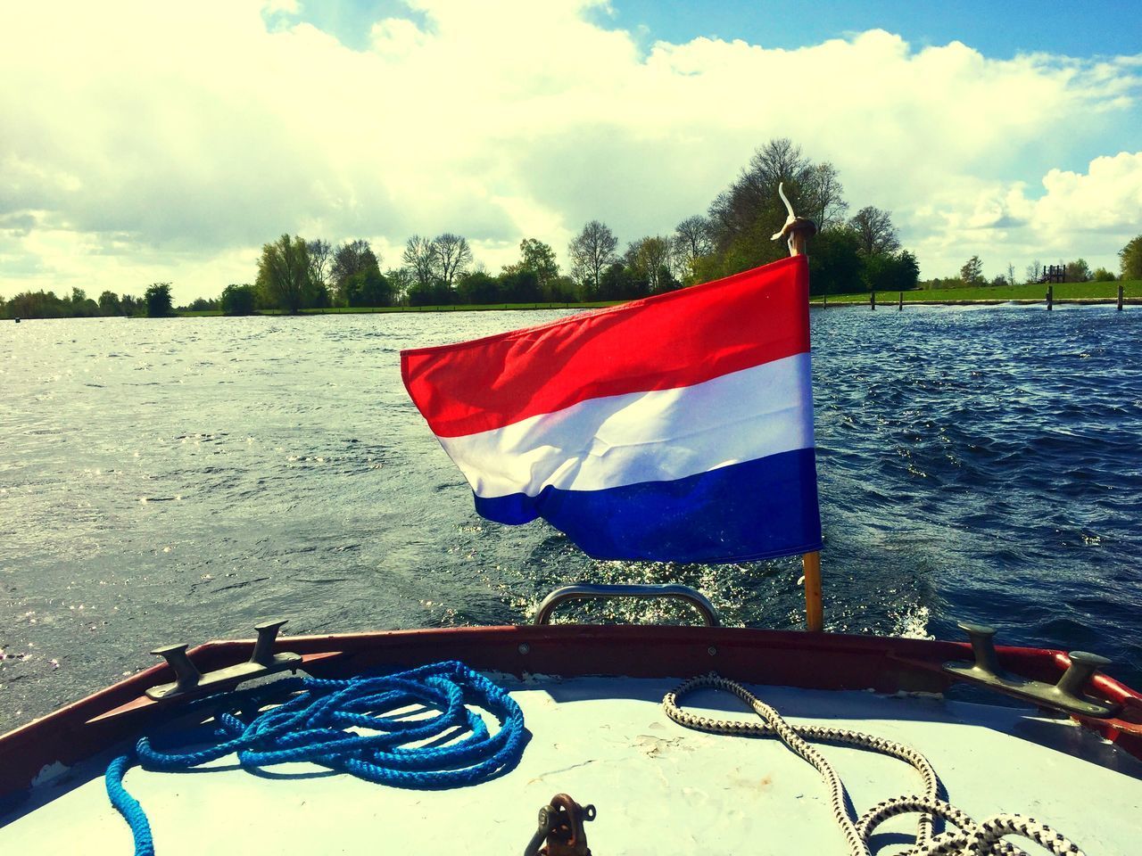 FLAG ON BOAT AGAINST LAKE