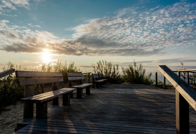 Pier over lake against sky during sunset