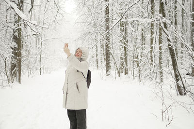 Young woman standing on snow covered landscape