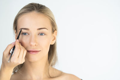 Portrait of a young woman over white background