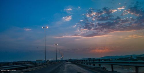 Road by street against sky during sunset