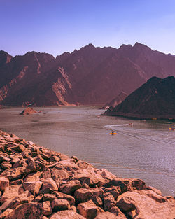 Scenic view of hatta lake and mountains against clear sky