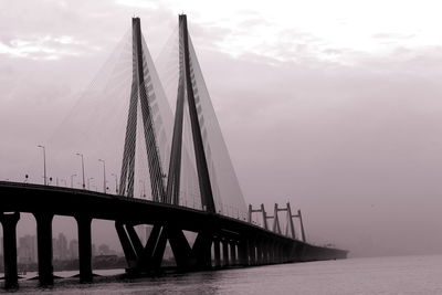 Suspension bridge over sea against sky
