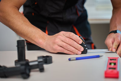 Midsection of man working on table