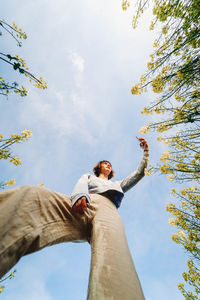 Low angle view of woman standing against sky