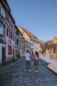 People walking on street amidst buildings in city