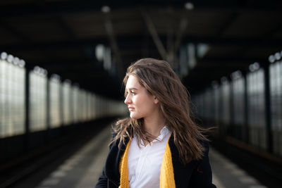 Portrait of woman standing at railroad station