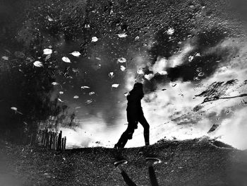 Reflection of people in puddle