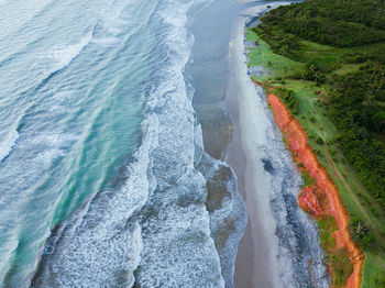 Beach view from the air with beautiful blue sea and pretty green forest