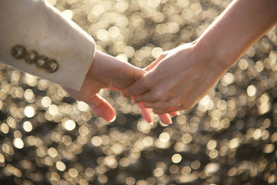 Cropped image of couple holding hands