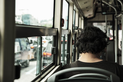 Rear view of man seen through train window