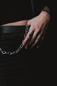 Close-up of hand holding hands against black background