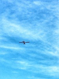 Low angle view of airplane flying against blue sky