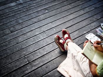 Low section of woman sitting on hardwood floor