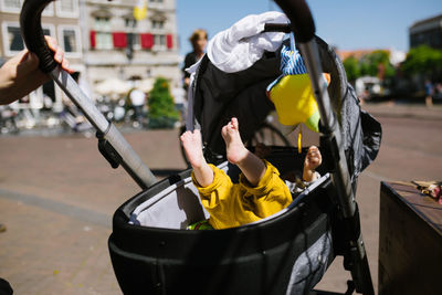 Cropped image of parent pulling baby stroller