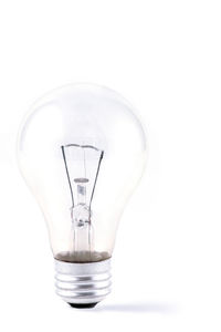 Close-up of illuminated light bulb against white background