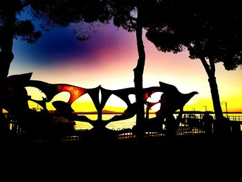 Silhouette trees against sky during sunset