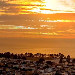 Aerial view of cityscape against sky during sunset