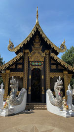 Statue in temple against blue sky