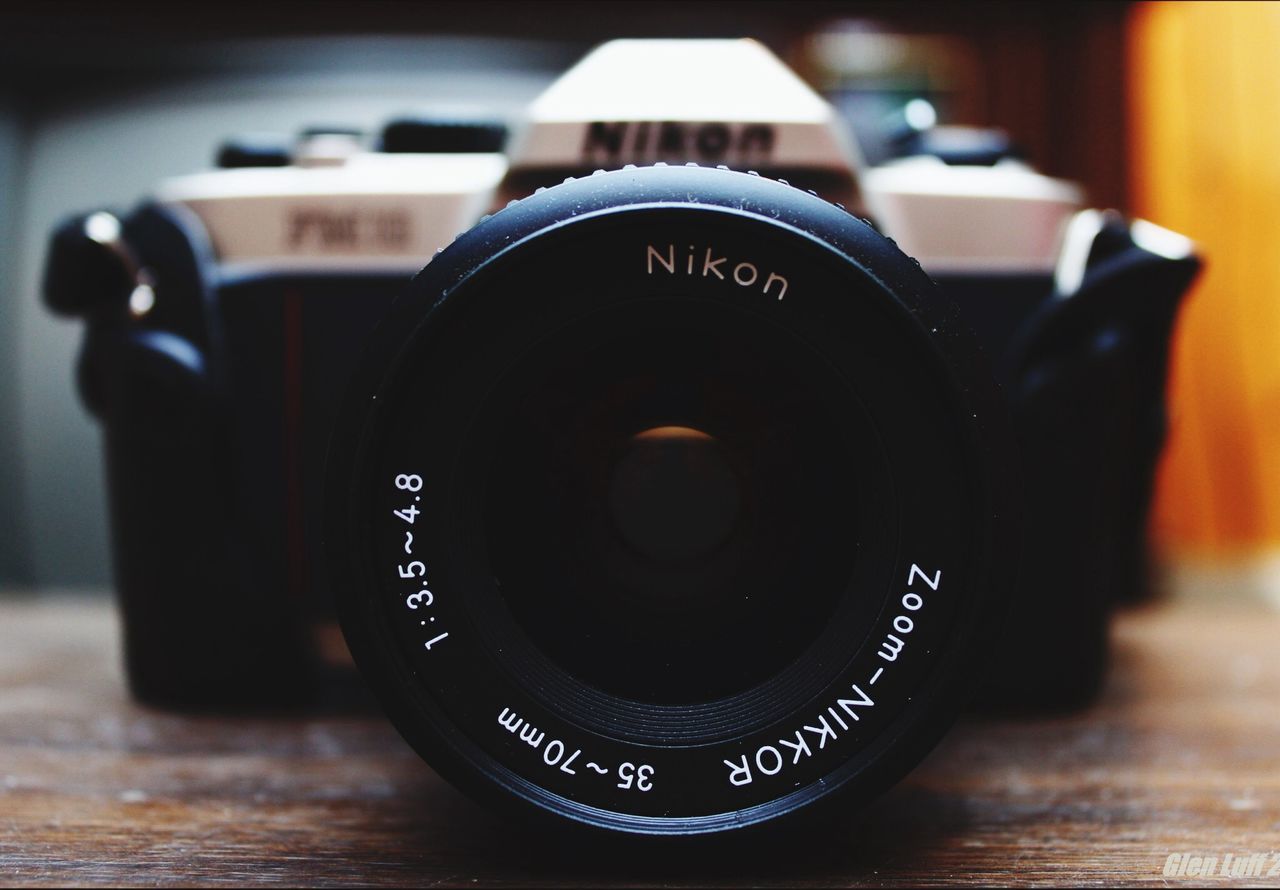 indoors, communication, close-up, photography themes, technology, camera - photographic equipment, focus on foreground, text, selective focus, table, still life, western script, number, single object, wireless technology, lens - optical instrument, retro styled, old-fashioned, black color, digital camera