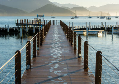 Wooden pier over sea against sky