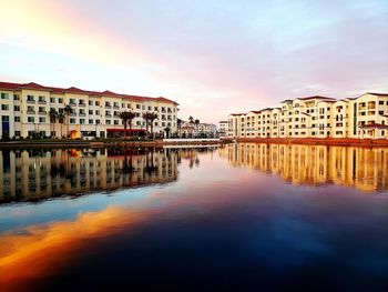 Reflection of buildings in lake against sky