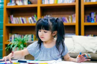 Cute girl painting on papers at home