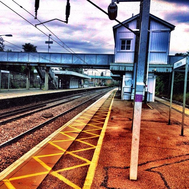 railroad track, rail transportation, railroad station platform, built structure, sky, architecture, building exterior, railroad station, public transportation, transportation, the way forward, empty, diminishing perspective, cloud - sky, cloud, city, sunlight, no people, outdoors, absence