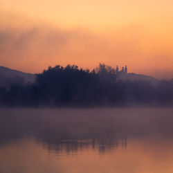 Scenic view of lake against orange sky