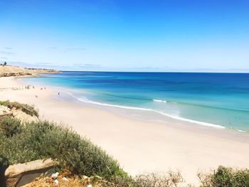 Scenic view of beach against clear blue sky