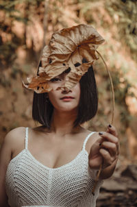 Portrait of woman holding autumn leaf