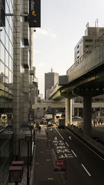 Traffic on road amidst buildings in city against sky