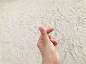 Close-up of human hand on sand