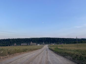 Road amidst field against sky