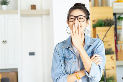 Portrait of young woman standing at home