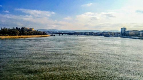 Scenic view of river against cloudy sky