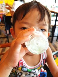 Close-up portrait of boy having drink in restaurant