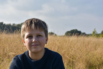 Portrait of boy on field against sky