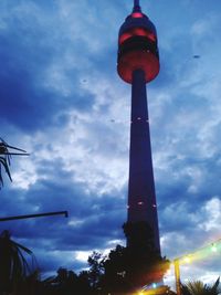 Low angle view of illuminated tower against sky at sunset