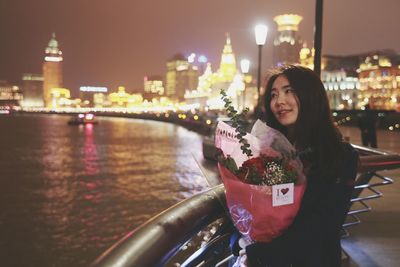 Woman standing in illuminated city at night