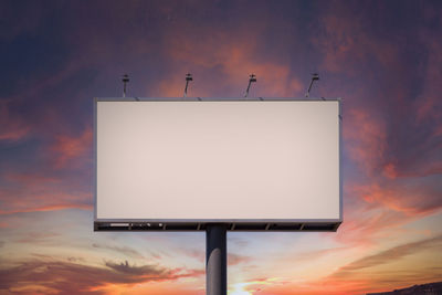 Blank billboard mock up for advertising, against dramatic sunset sky