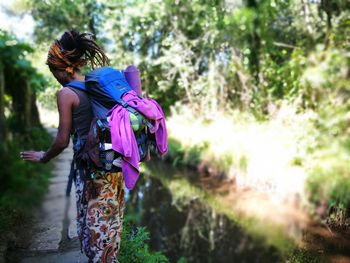 Rear view of woman standing against trees