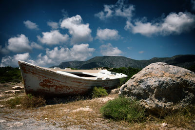 Abandoned boats on beach against sky