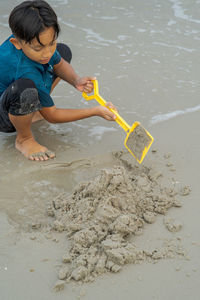 High angle view of girl playing on sand at beach