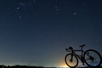 Bicycles against sky at night