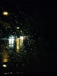 Close-up of illuminated lights against sky at night
