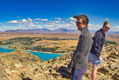 People standing on mountain against sky