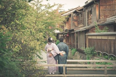 Rear view of man and woman walking on plants