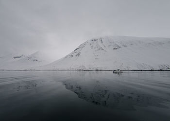 Scenic view of lake and snowcapped mountains against sky