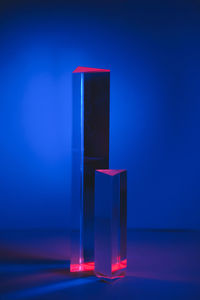 Close-up of illuminated candle against blue background